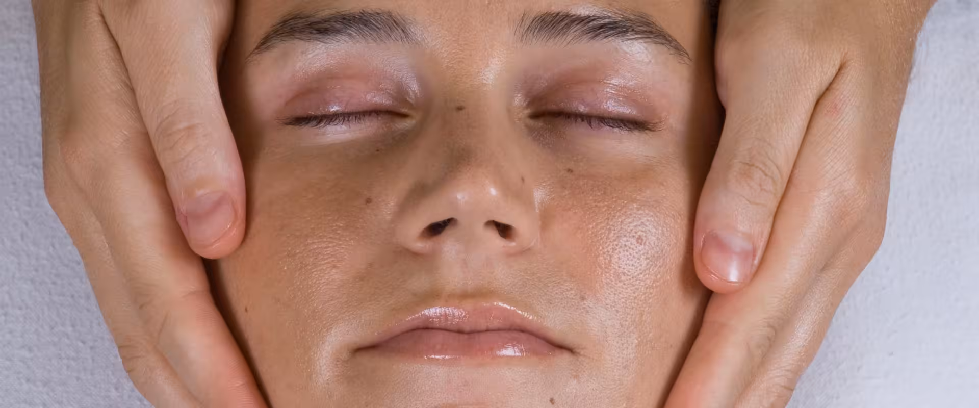 Terapeuta especializado do Instituto Ahau aplicando Terapia RESET com toques energéticos na mandíbula, demonstrando técnica de Kinergetics para alívio de tensão, equilíbrio neuromuscular e bem-estar integral